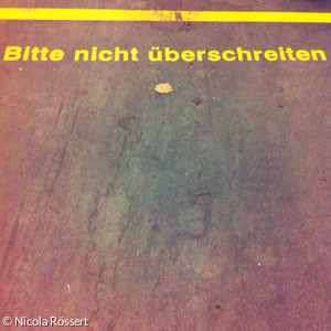 Gelbe Linie auf rosa Grund: "Bitte nicht überschreiten"